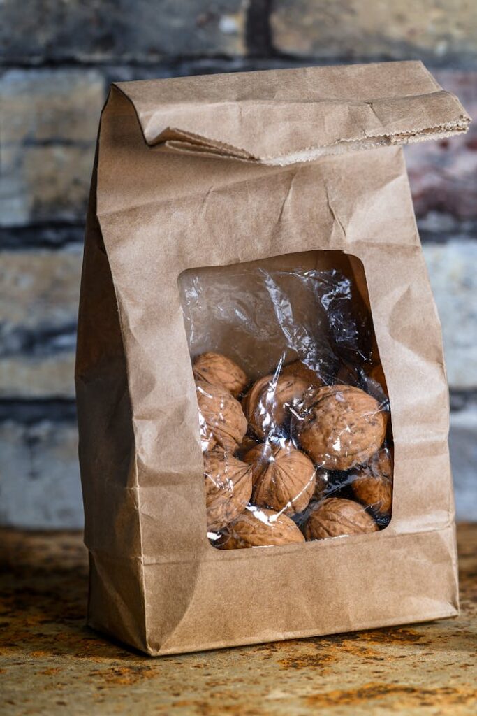Close-up of walnuts in eco-friendly paper bag on textured surface, perfect for organic and sustainable themes.