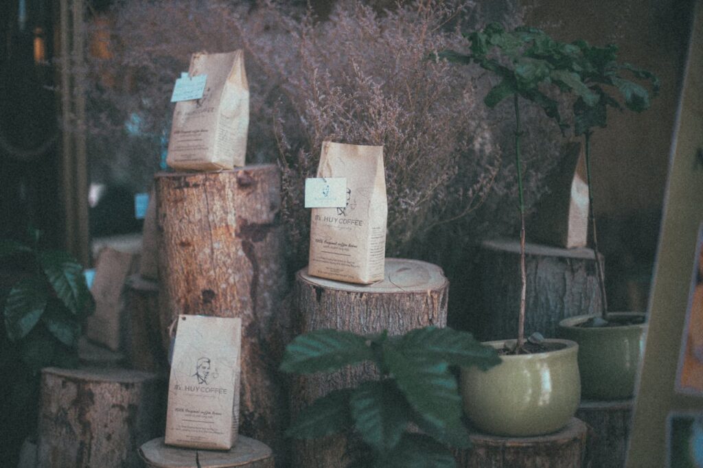 Charming rustic coffee bags displayed on wood logs with vintage touch and greenery.