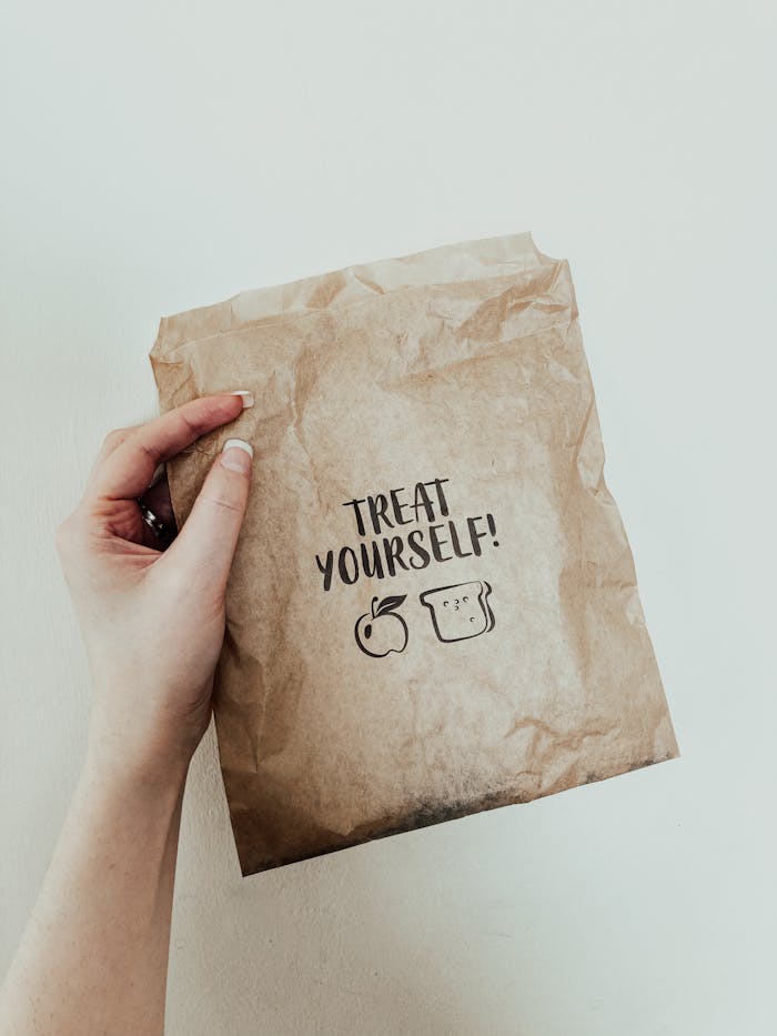 Crafting Captivating Headlines: Your awesome post title goes here Crop unrecognizable female demonstrating grocery store craft package with Treat Yourself inscription against white background